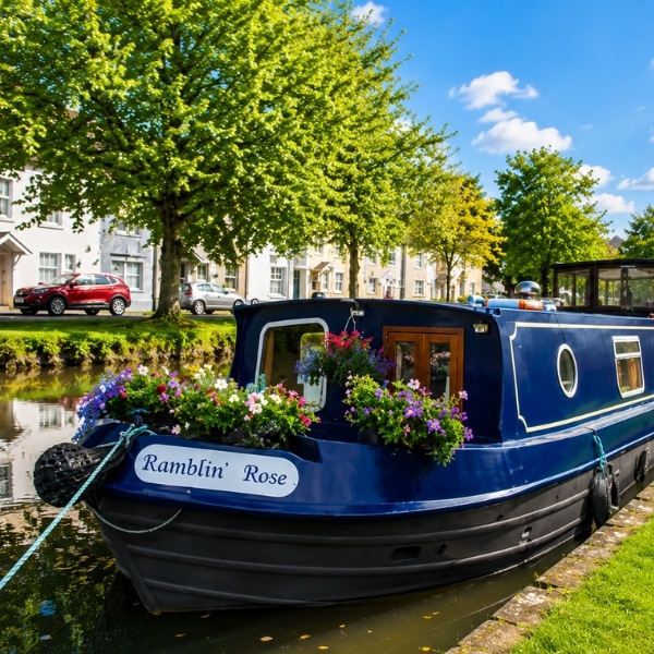 Close-up bow view of Ramblin Rose canal barge decorated with colourful hanging flower baskets on the Grand Canal Ireland